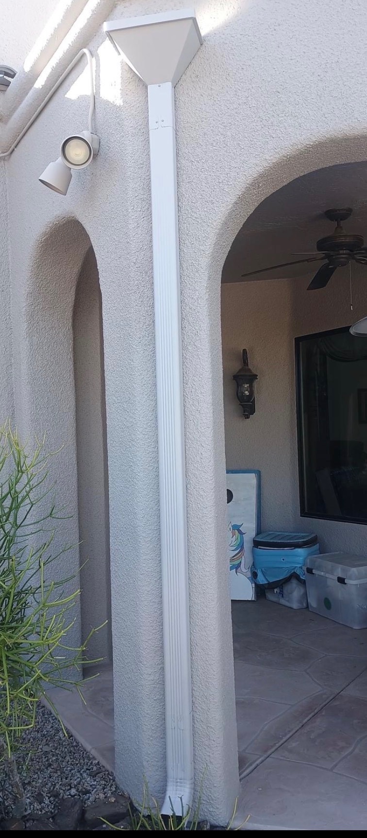Close-up of a white seamless downspout with a decorative scupper top